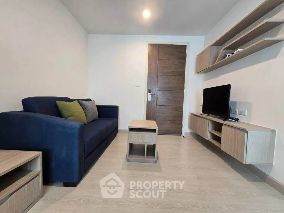 Modern living room with sleek furniture and wall-mounted TV in a stylish apartment.