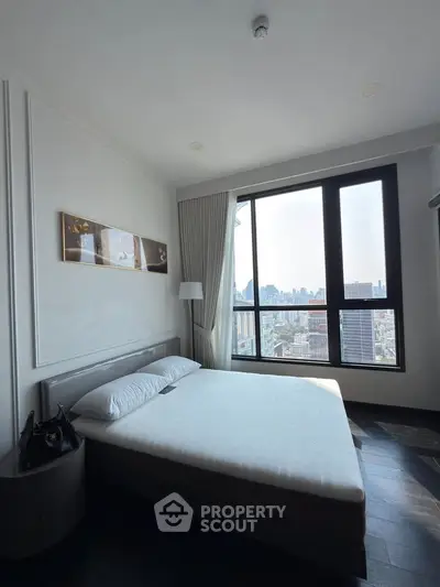 Modern bedroom with city view, featuring large window and stylish decor in urban apartment.
