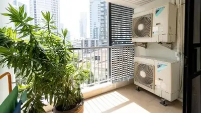 Spacious balcony with city view and air conditioning units
