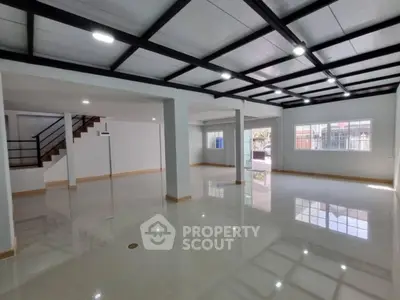 Spacious open-plan interior with modern ceiling design and large windows
