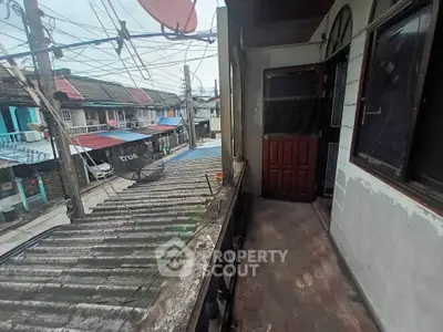 Charming balcony view of a rustic neighborhood with satellite dishes and colorful rooftops.