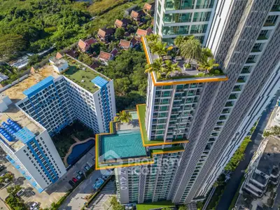 Stunning aerial view of modern high-rise building with rooftop pool and lush greenery, offering luxurious urban living.