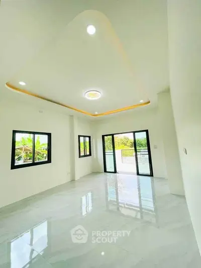 Spacious modern living room with large windows and glossy floors