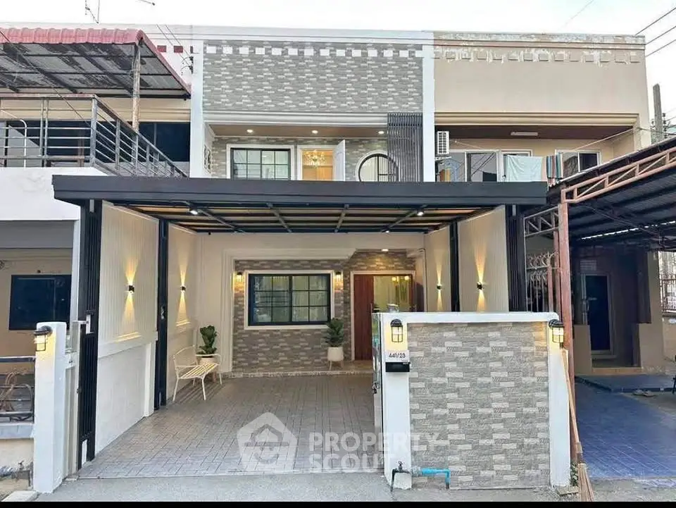 Modern two-story house with stylish facade and spacious carport in urban setting.