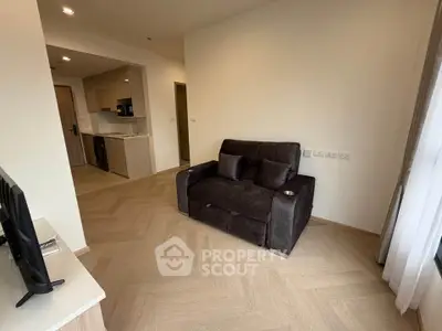 Modern living room with cozy sofa and open kitchen layout in a stylish apartment.