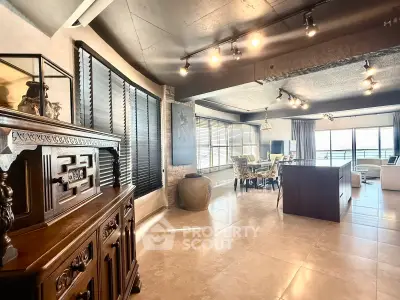 Spacious open-plan living and dining area with elegant decor and large windows.