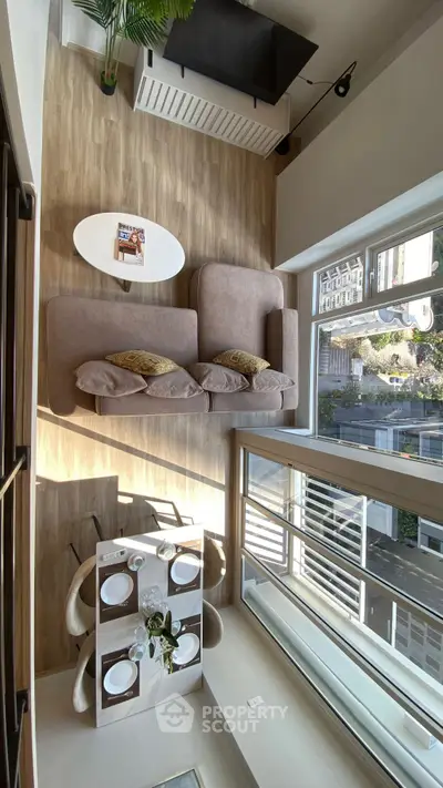 Modern living room with large windows and stylish furniture, offering a bright and inviting atmosphere.