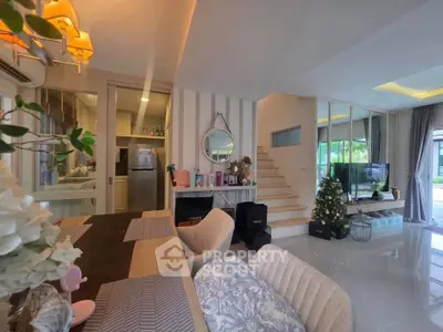Modern open-plan living room with stylish decor and Christmas tree, featuring a dining area and staircase.