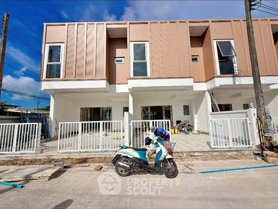 Modern townhouse exterior with clean lines and contemporary design, featuring a spacious front area and sleek facade.
