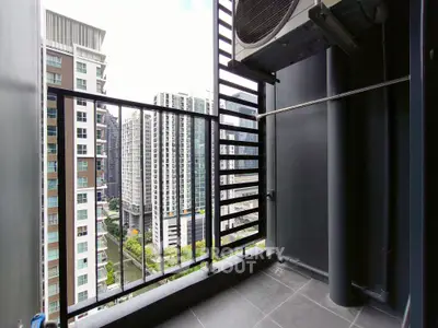 Modern high-rise balcony with cityscape view and sleek railing design.