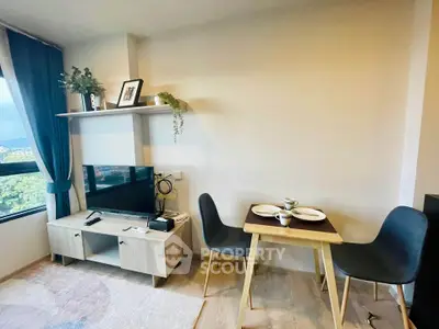 Cozy living room with dining area, modern decor, and natural light from large window.