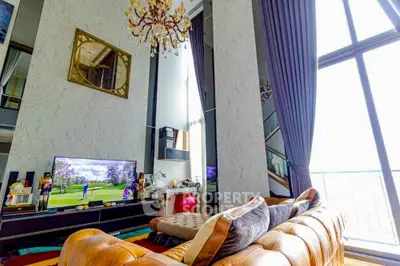 Luxurious living room with high ceilings, elegant chandelier, and large windows offering stunning views.
