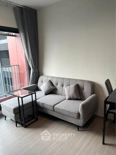 Modern living room with sleek gray sofa and stylish furniture, perfect for urban living.
