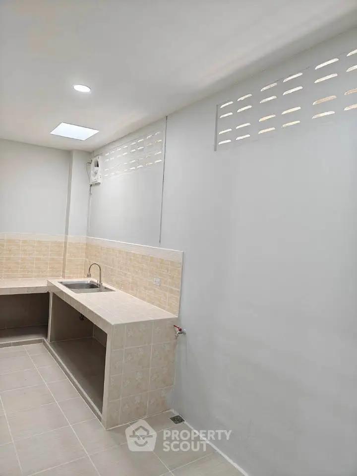 Spacious kitchen with tiled countertops and ample natural light