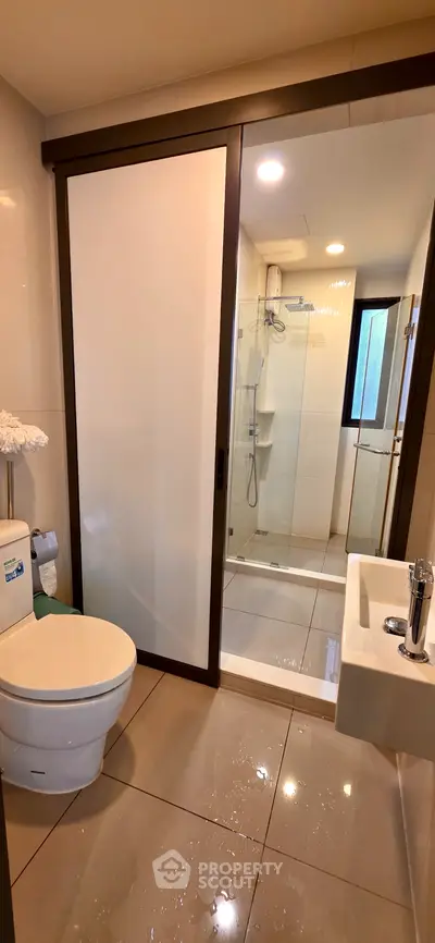 Modern bathroom with glass shower and sleek fixtures, offering a clean and contemporary design.