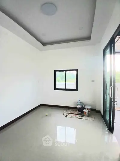 Bright empty room with glossy floor and large window, ideal for customization.
