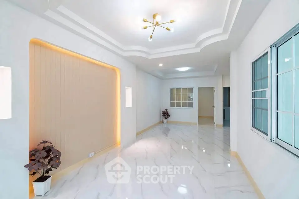 Spacious modern living room with elegant lighting and marble flooring.