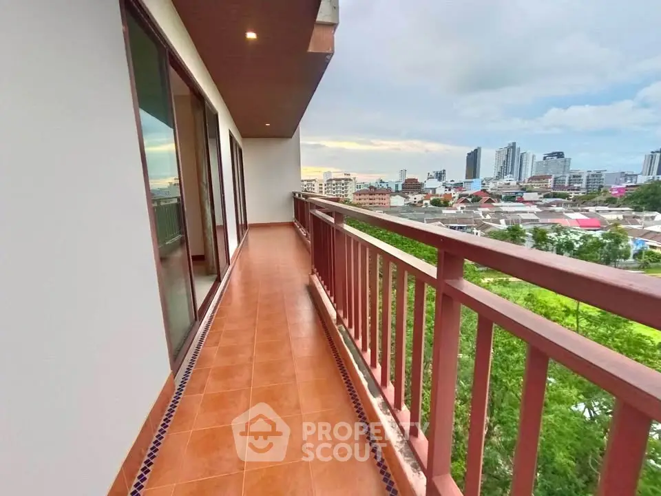 Spacious balcony with stunning city view and modern railing design.