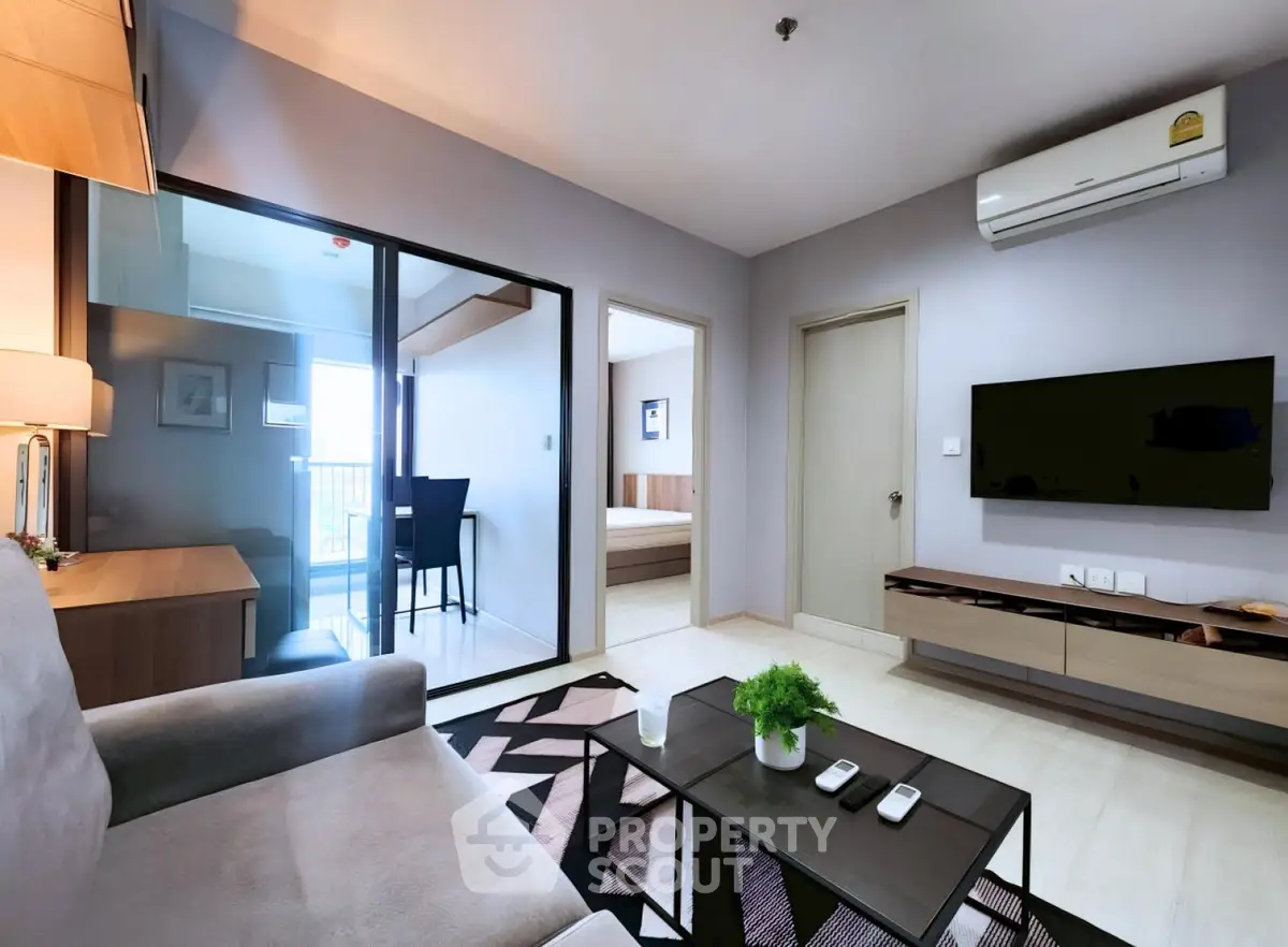 Modern living room with sleek furniture and balcony view in a stylish apartment.