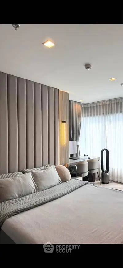 Luxurious modern bedroom with elegant decor and ample natural light.