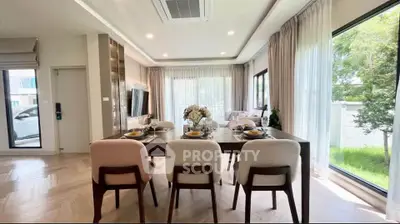 Elegant dining room with large windows and stylish decor in a modern home.