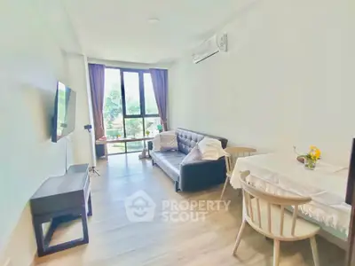 Bright modern living room with large windows and cozy furnishings.