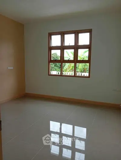 Spacious empty room with large window and glossy tiled floor