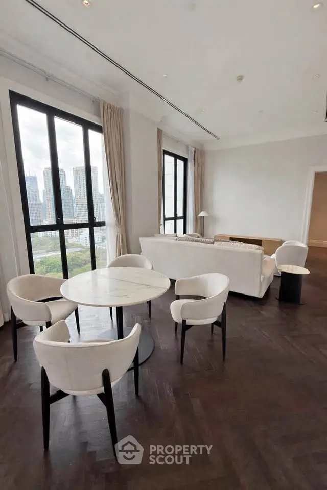 Luxurious living room with elegant dining set and stunning city view, featuring floor-to-ceiling windows.