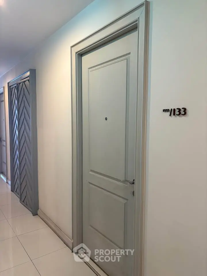 Modern apartment hallway with sleek door design and polished flooring.