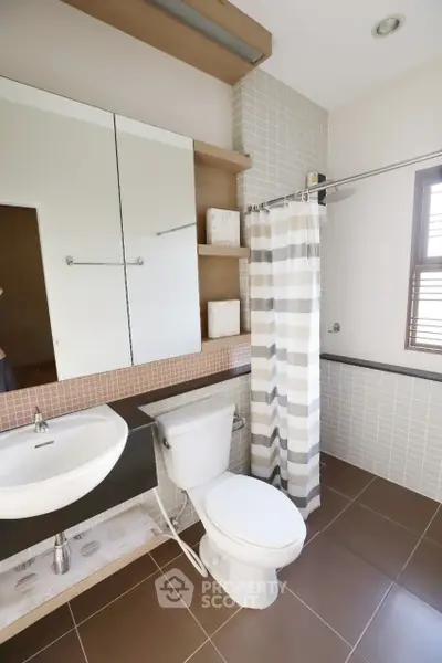 Modern bathroom with stylish tiles and shower curtain in a contemporary home.