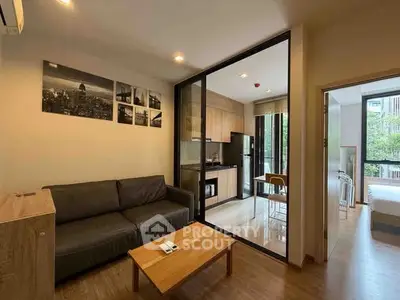 Modern apartment with open kitchen and cozy living room, featuring stylish decor and natural light.