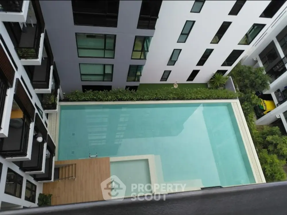 Modern apartment complex with a stunning rooftop pool and lush greenery