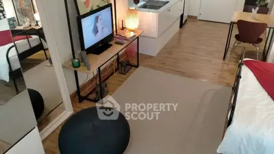 Cozy studio apartment with modern decor and open layout, featuring a compact kitchen and stylish living area.