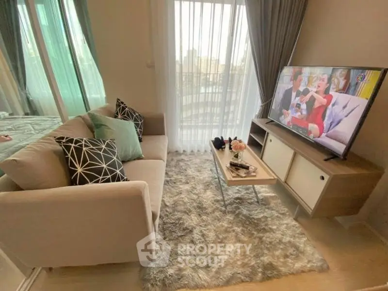Cozy living room with modern decor and large TV, perfect for relaxation.
