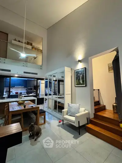 Spacious modern living room with high ceilings and open kitchen layout, perfect for entertaining.