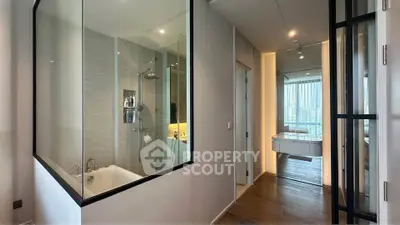 Modern apartment interior with glass-walled bathroom and city view