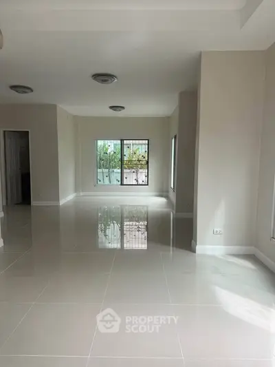 Spacious empty living room with large windows and glossy tiled floors, perfect for customization.