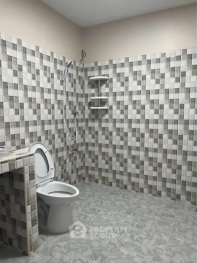 Spacious bathroom with modern tiled design and shower area.