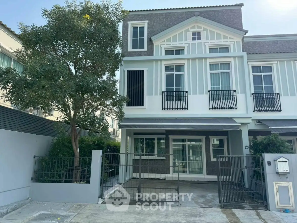 Charming two-story townhouse with modern facade and gated driveway in a serene neighborhood.