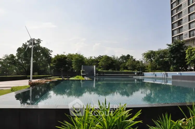 Luxurious apartment complex with stunning infinity pool and lush greenery.