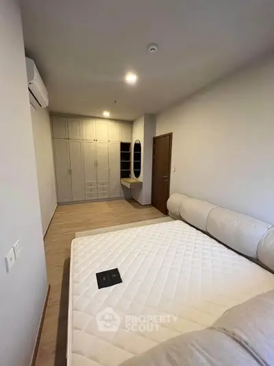 Spacious bedroom with modern furnishings and ample storage in a stylish apartment.