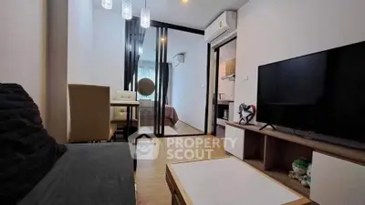 Modern living room with sleek furniture and open view into bedroom, featuring air conditioning and stylish decor.