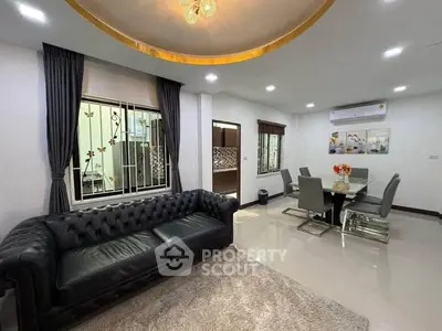 Spacious modern living room with elegant dining area and luxurious leather sofa.