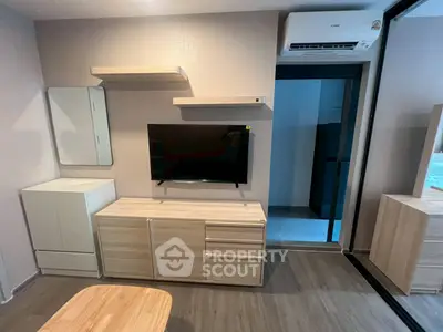 Modern living room with sleek furniture and wall-mounted TV in a cozy apartment.
