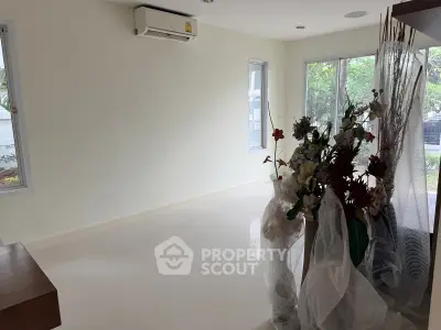 Spacious living room with large windows and air conditioning, perfect for natural light and comfort.