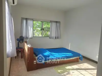 Bright bedroom with natural light and simple furnishings