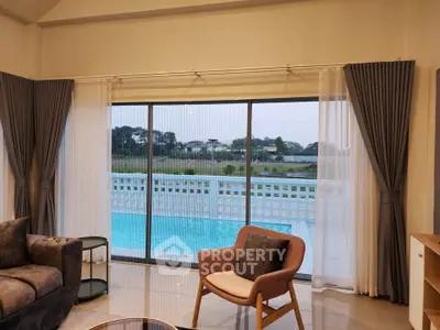 Luxurious living room with pool view, featuring elegant curtains and modern furniture, perfect for relaxation.