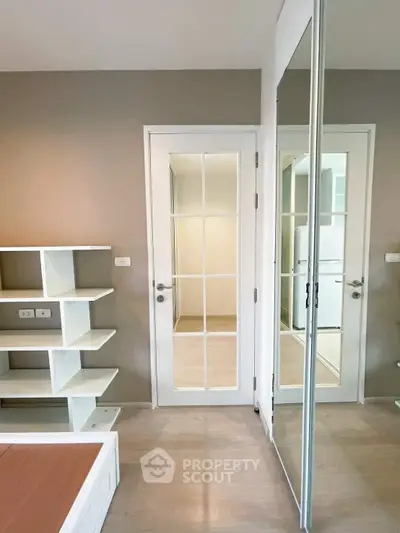 Modern interior with mirrored closet and elegant shelving in a stylish apartment