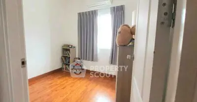Cozy bedroom with wooden flooring and natural light, perfect for relaxation.
