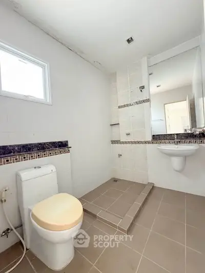 Spacious modern bathroom with sleek fixtures and tiled shower area